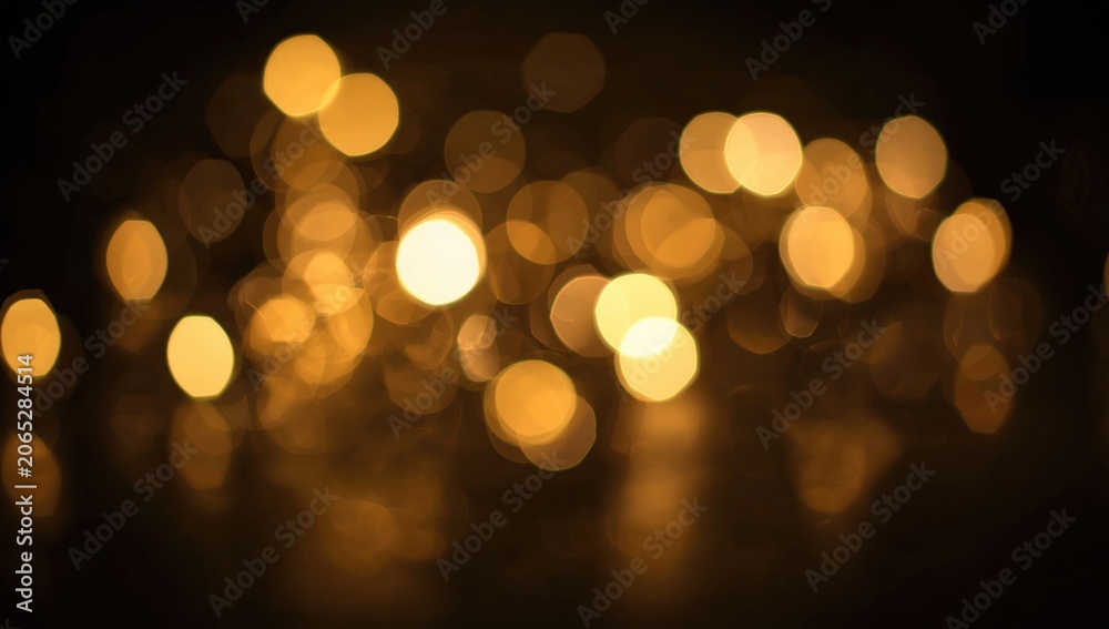 Fototapeta premium Golden bokeh lights against a dark background