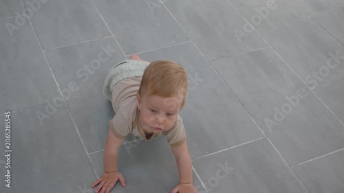 Baby learns happiness. Young child shifts from tummy lying to confident walking with joy. Young child makes cheerful progress from tummy time to to stand around house with happiness