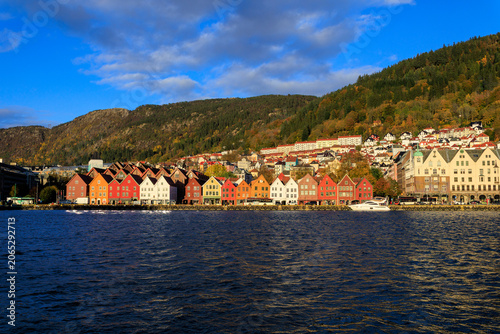 Panorama of Bergen Port with colorful wooden hanseatic buildings of World Heritage Site Bryggen, boat and mountain in autumn in Norway