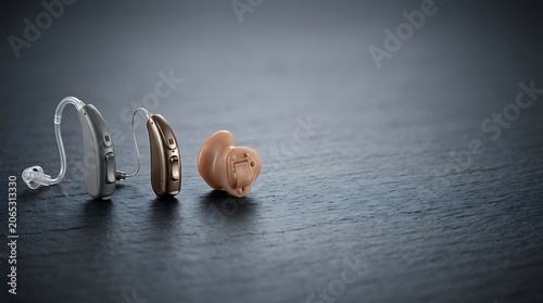 Modern hearing aids in different styles on dark background