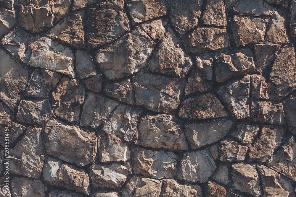 Fototapeta premium Natural stone wall showcases a beautiful array of textures and colors, inviting a sense of rugged elegance to any surroundings