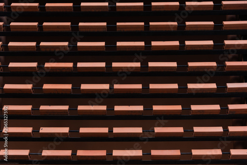 Close-up of contemporary architectural details featuring repeating rows of orange clay bricks installed on a metal frame.