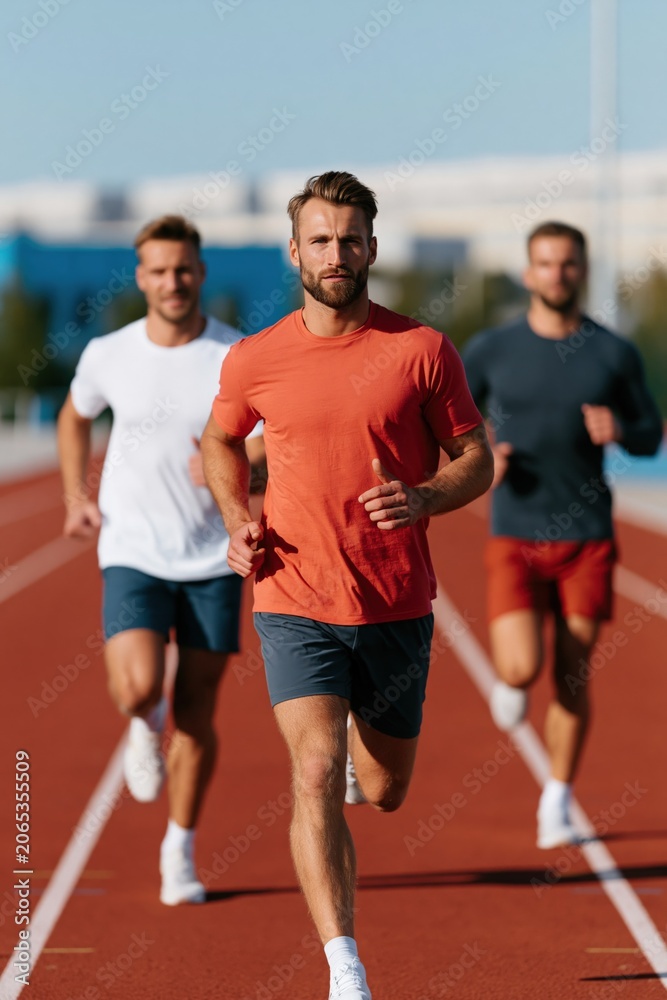 Fototapeta premium Male athletes running on outdoor track background with competitive sprinters for fitness banner and sports training poster