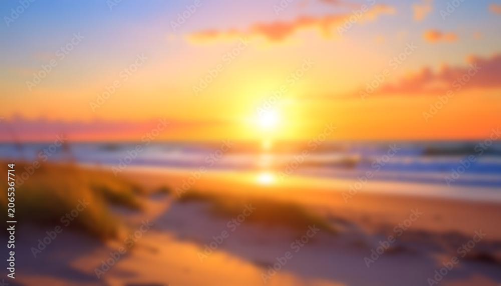 Obraz premium Radiant beach sunset over gentle waves with glowing sky.