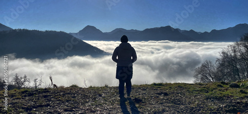 Frau (Wanderer) von hinten blickt von oben auf ein Wolkenmeer, Samerberg, Alpen, Bayern, Deutschland