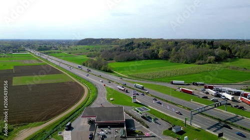 Aerial drone footage of E314 highway with Esso gas station and truck rest area in Rotselaar, Belgium surrounded by green farmland