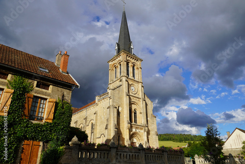 St Pierre church, Église Saint-Pierre in Pouilly-en-Auxois (1868) with dark rain clouds and blue sky. June, France, Burgundy.