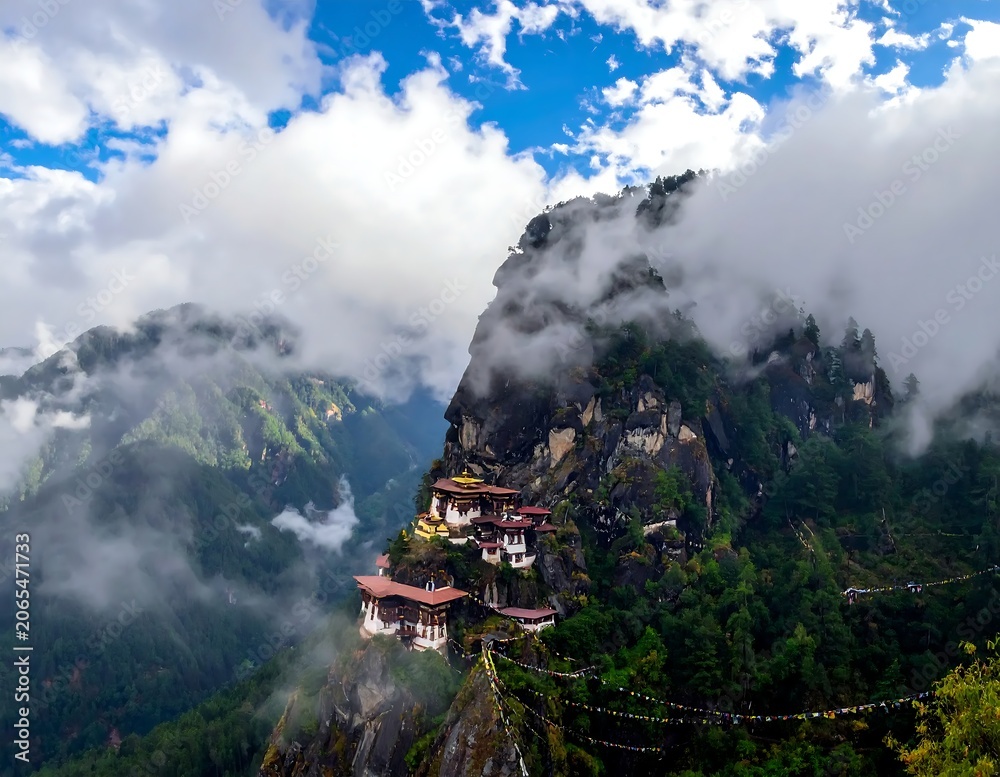 Fototapeta premium Misty Mountain Monastery Perched on Rocky Cliff in Lush Himalayan Valley