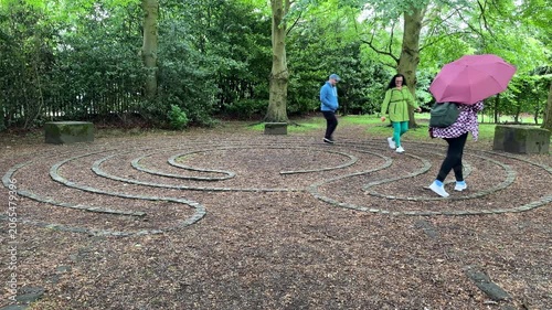 People having fun walking stone labyrinth or maze in the park.