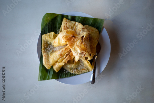 Fotografi Roti Canai, Cane Cake served on green banana leaves, sprinkled with granulated s