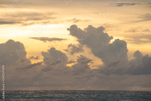 Foto Golden sunset over calm sea with dramatic clouds and colorful sky reflected on w