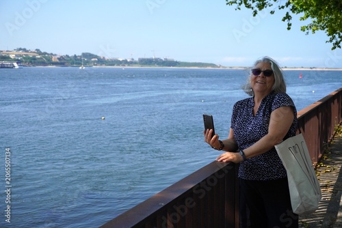 Senior woman taking a picture with her phone on vacation