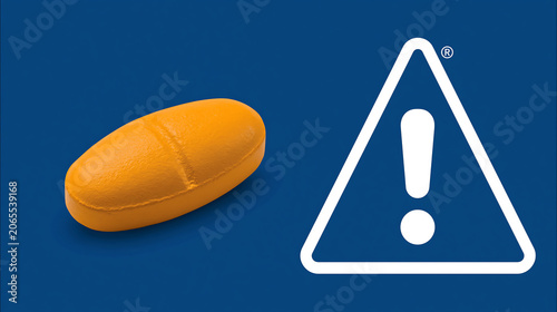 dangerous pharmaceutical pill capsule beside exclamation warning triangle sign on red background health and medicine alert concept