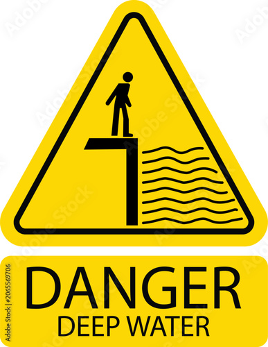 Yellow triangular danger sign warning for deep water hazard with a person standing by a cliff