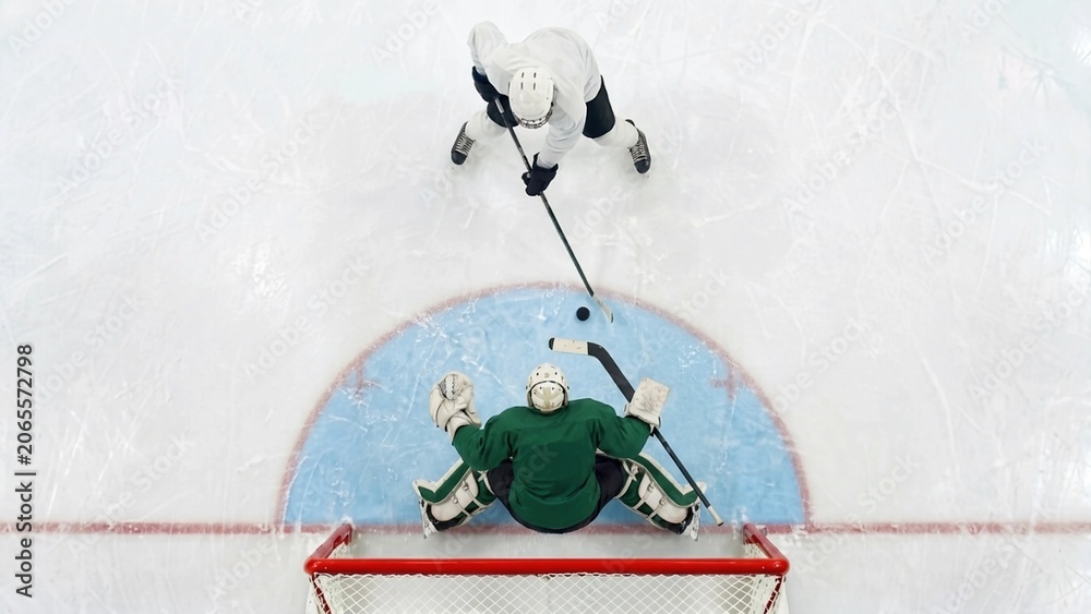 Naklejka premium Ice hockey player attacking goal against goalkeeper from overhead view. Concept of professional hockey competition, goal scoring and tactical sports performance.
