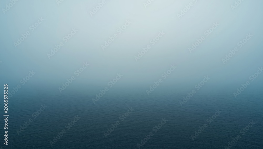 Naklejka premium Foggy ocean surface under a pale sky