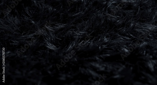 Close up of a luxurious shaggy black fur carpet texture with detailed strands
