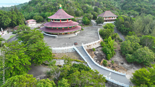 Foto Full aerial view of the grand Puri Tri Agung temple complex and courtyard surrounded by lush tropical forest in Bangka Island, Indonesia