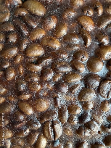 Fotografie Close-up of coffee beans embedded in a dark, glossy, and textured surface, possibly a resin or hardened sugar, creating an intriguing abstract pattern for backgrounds or food-related designs