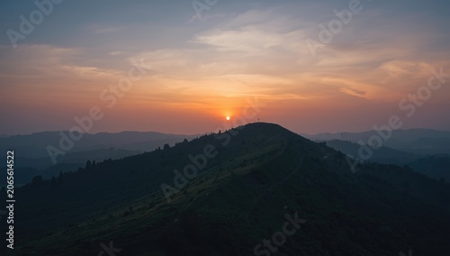 Sunset over rolling hills a...