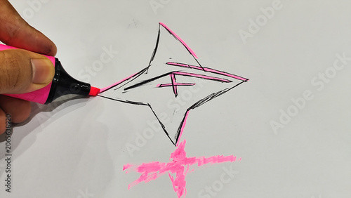 фотографія Close-up of a human hand drawing a star shape doodle using a pink neon highlight