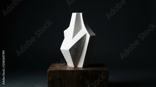 Modern white geometric ceramic vase on wooden pedestal