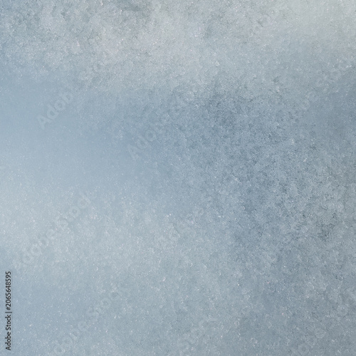 Macro photography of natural coarse snow texture with soft sunlight and subtle blue transitions, square crop