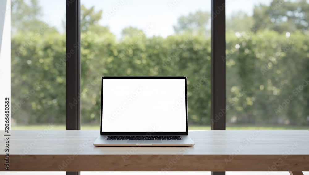 Fototapeta premium Modern Laptop Computer with White Screen on Wooden Desk in Front of Large Window