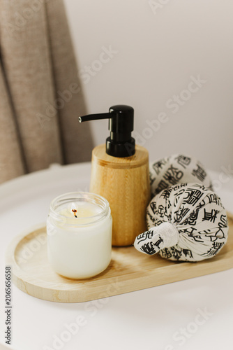 Still life of luxury spa essentials. A bottle with a massage oil and candle on a table.