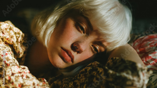 Portrait de jeune fille blonde la tête posée sur son bras