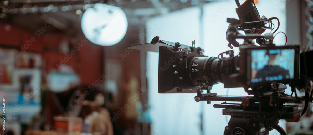 Obraz premium Professional cinema and video camera on the set. Shooting shift, lighting fixtures, shooting equipment and the team.