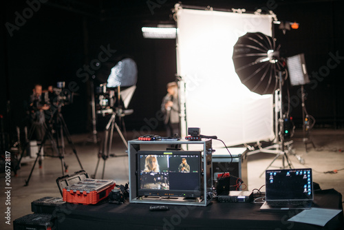 Film set, monitors and modern shooting equipment. Filming crew, lighting devices, monitoring, playback - filming equipment and a team of professionals in filming movies, ads and TV series.