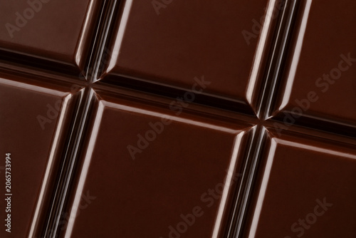 Close-up texture of a gourmet dark chocolate bar squares