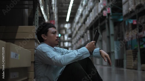 Tired Warehouse Employee Taking a Break After Long Working Shift. Work fatigue, employee wellbeing, warehouse workforce