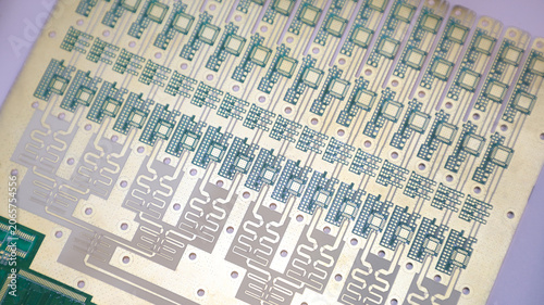 An intricate golden and silver printed circuit board matrix panel showing micro lectronic footprints.