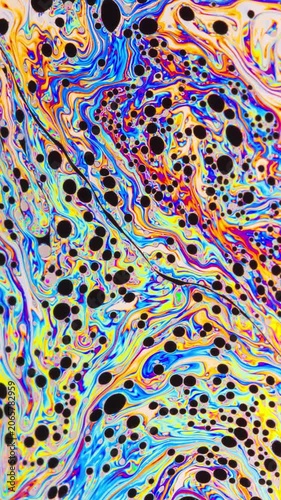 Macro shot of a soap bubble creates a colorful and psychedelic background. Vertical Video.