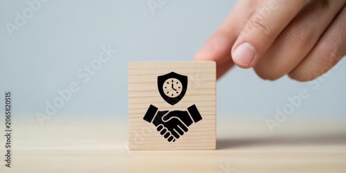Hand placing wooden block with time management and productivity icons on table