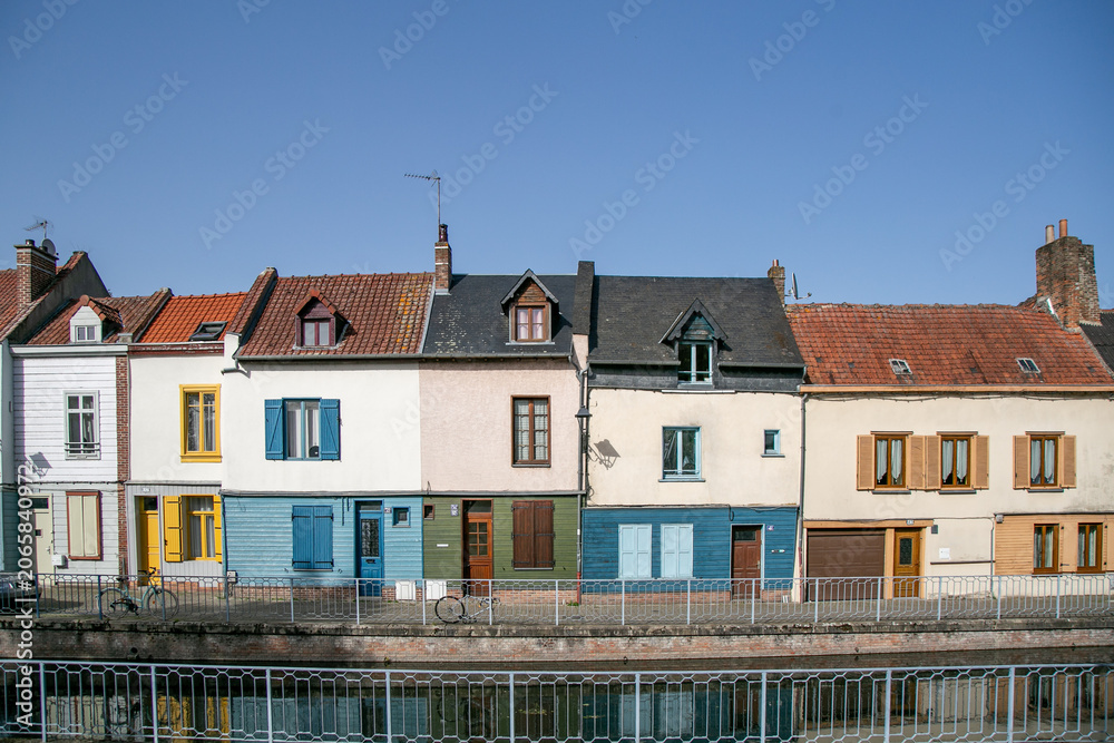Fototapeta premium Historic Saint-Leu district along the River Somme in Amiens, France. The picturesque neighbourhood features colourful old townhouses, riverside canals, and traditional waterways 