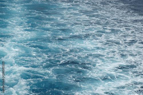 Valokuva A close up view shows texture of churning blue water and white foam created by a fast moving ship in the open sea