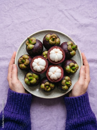 Hands Holding Fresh Mangosteen Fruits