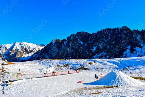 Präparierte Skipiste im Skigebiet Vounetse bei Charmey vor den markanten Felsgipfeln der Voralpen (Schweiz)