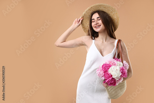 Woman with bouquet of beautiful peony flowers on beige background, space for ...