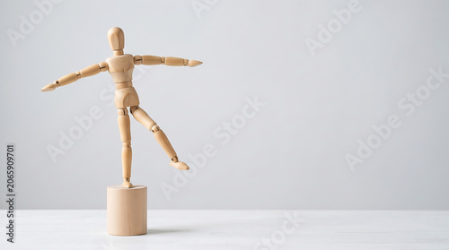 Business agility and professional balance concept with wooden mannequin posing for corporate performance and stability presentation background