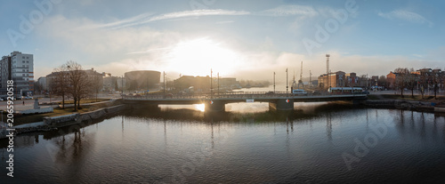 Obraz na plátně Winter sunburst aligned with bridge span over river in port city