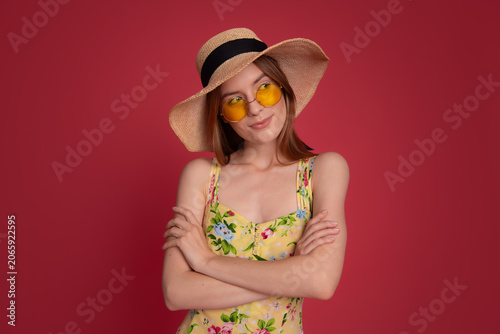 Confident woman in straw hat and sunglasses
