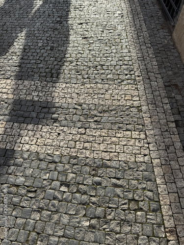 Billede på lærred patterned paving stones in the pedestrian area with shadows, textured background