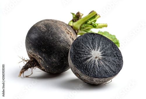 Two black radishes, one whole and one sliced, on a white background with bright lighting