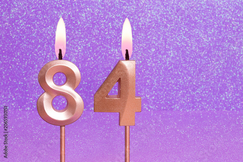 Number 84 on a pink background with blurred bright dots - Birthday or anniversary card with abstract blurred dots that glow