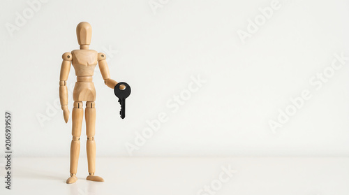 Employee performance tracking and KPI evaluation concept with wooden mannequin holding key and copy space for corporate business presentation slide banner
