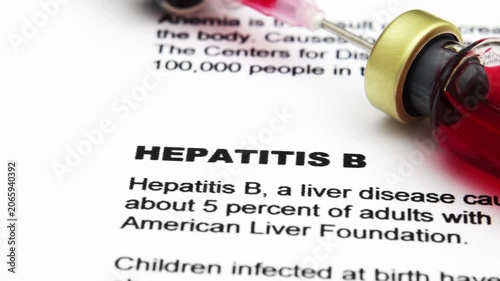 Hepatitis B Vaccine and Syringe on Medical Document Close Up